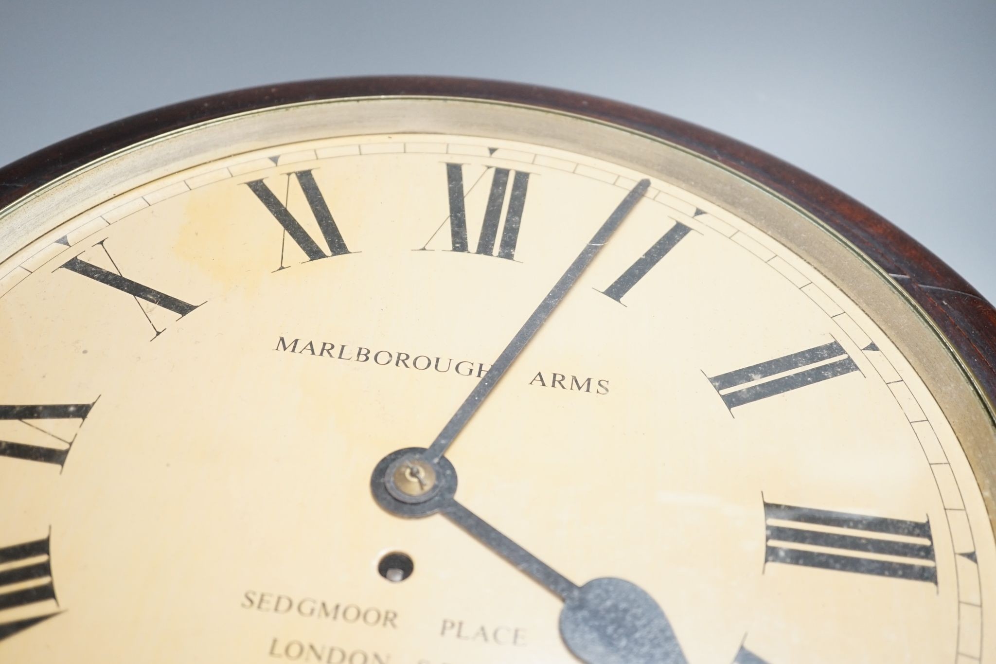 A mahogany dial clock, Marlborough Arms, Sedgmoor Place, London SE5., 48 cms diameter.